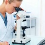 Врач смотрит в микроскоп