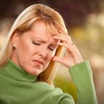 Женщина держится за голову